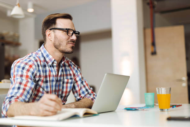 istock Happy man  working on laptop at home 1393340771