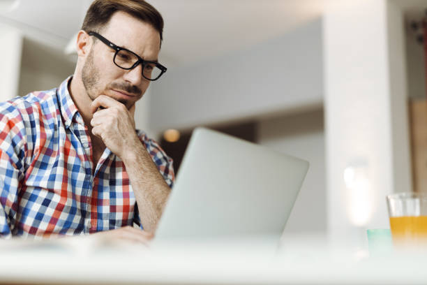 istock Thoughtful man working on laptop at home 1393341906