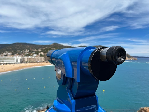 spyglass or telescope pointing towards the sea, blurred background