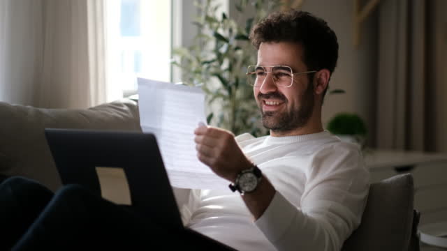 Businessman opening envelope reading letter with good news celebrating success