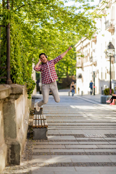 istock Modern young smiling man enjoying music outdoor 1393343134