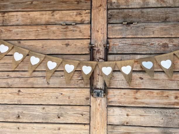 istock Wooden wall with white heart shaped signs on small flags 1393344377