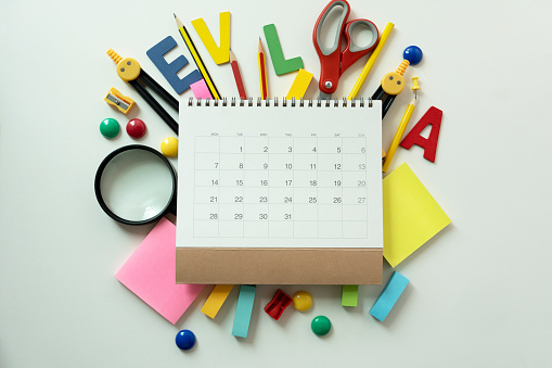 Different stationery and calendar on white table background, flat lay. Space for text, back to school concept