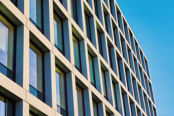 istock Modern building facade with windows against blue sky 1393349490