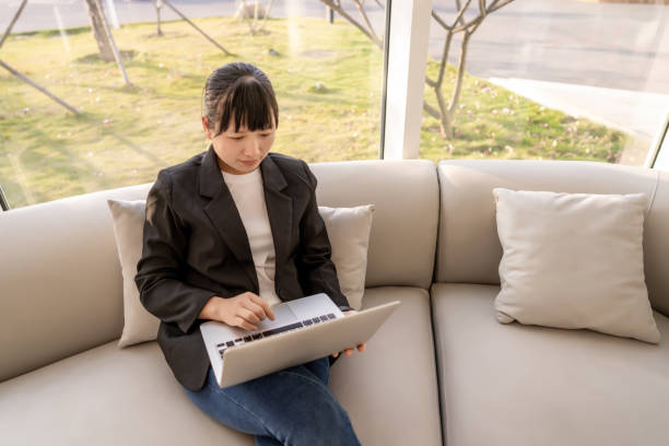 istock A white-collar worker sits on the sofa at home and uses the computer to work 1393350580