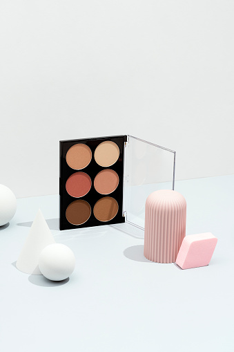 Cosmetics flat lay, packaging mockup, template with geometric objects on white and gray background. Blusher, makeup palette with sphere, cone and geometric shape objects.