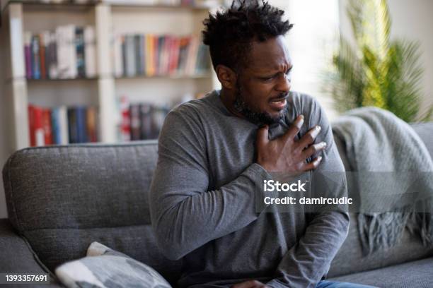 Closeup Photo Of A Stressed Man Who Is Suffering From A Chest Pain And Touching His Heart Area Stock Photo - Download Image Now