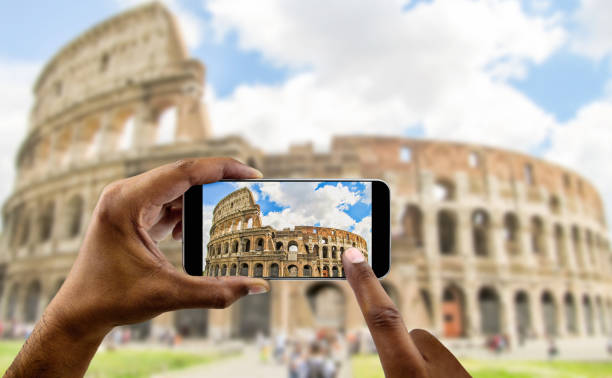 istock taking a photo of coliseum at Rome 1393357698