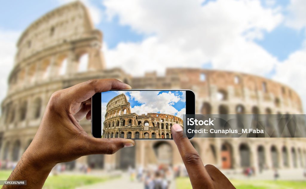 taking a photo of coliseum at Rome tourist takes a picture with his mobile of coliseum in Rome in Italy Rome - Italy Stock Photo