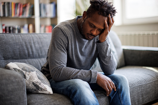 Worried man sitting on couch at home