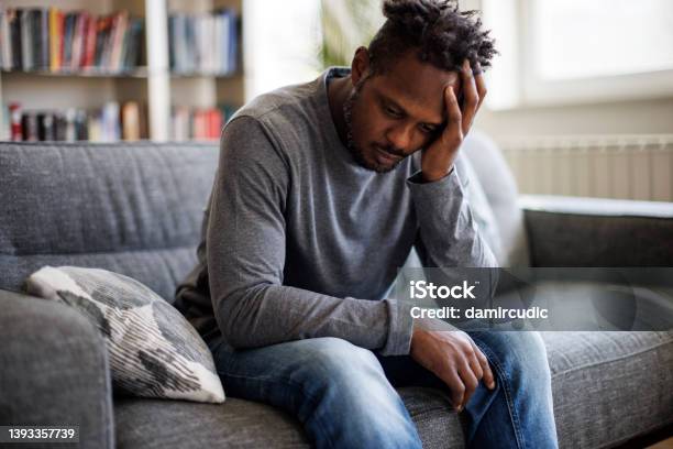 Worried Man Sitting On Couch At Home Stock Photo - Download Image Now - Men, Depression - Sadness, Sadness