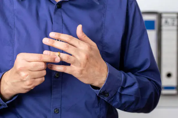 Hands of latin male who is about to taking off his wedding ring at the lawyer's office