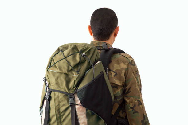 The back of the man with big blue backpack on the white background ready to travel.