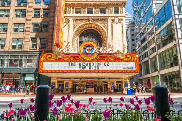 Chicago, Illinois, USA - May 16, 2018: Passerbys in front of the landmark Chicago Theatre on State Street with spring flowers. The historic theater dates from 1921.