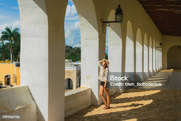 Woman Walking Among Columns In Izamal Town In Mexico Stock Photo - Download Image Now