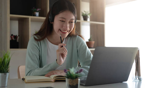 istock Curious Asian students while studying online on the internet and laptop video conferencing teachers at home. 1393363713