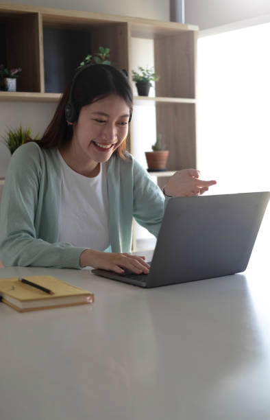 istock Asian student in casual clothes explaining homework on video conference with teachers on laptop computers at home 1393363772