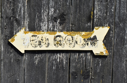 Old tea room sign on old wood with lichen