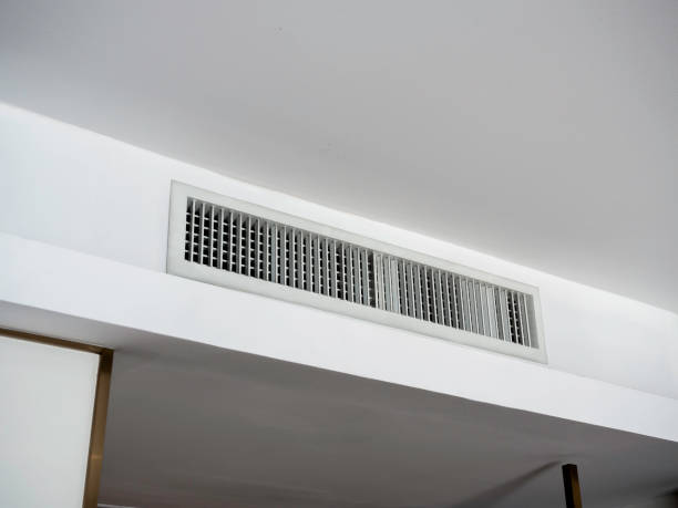 白いホテルの部屋の天井にエアコンの壁に取り付けられた換気システム。ホテルの部屋の換気グリルは壁に。 - air flow ストックフォトと画像