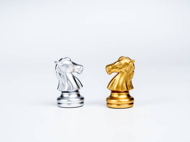 istock The confrontation between golden and silver horses, knight chess piece standing together isolated on white background. Leadership, partnership, competitor, competition, and business strategy concept. 1393367830