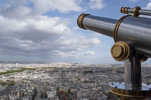 Paris: aerial view seen from the top of the Eiffel Tower with binoculars, the city skyline and the Saint Louis cathedral with its golden dome in the Les Invalides complex