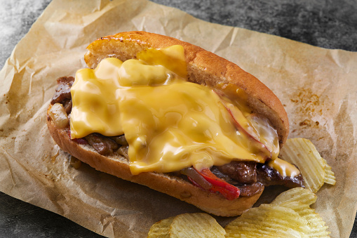 Top Sirloin Steak Sandwich with Onions, Red Peppers and American Cheese