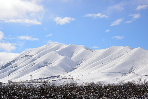 Gagra, Samangan province, Afghanistan: large jail compound on the foothills and scenic view of snow covered mountains