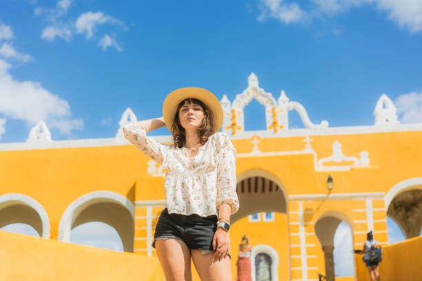 woman walking in izamal town in mexico - women rear view one person arch imagens e fotografias de stock