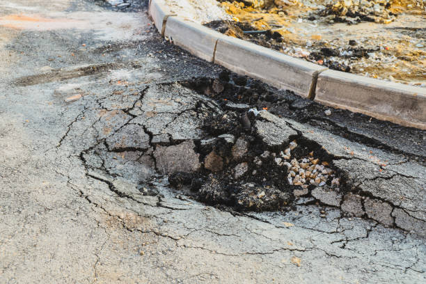 Asphalt swelling close-up. Pothole and pit on road stock photo