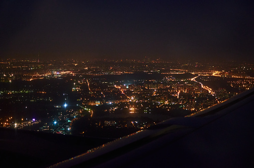 view from the window of the plane on the night city. bird's eye view of city lights at night. High quality photo