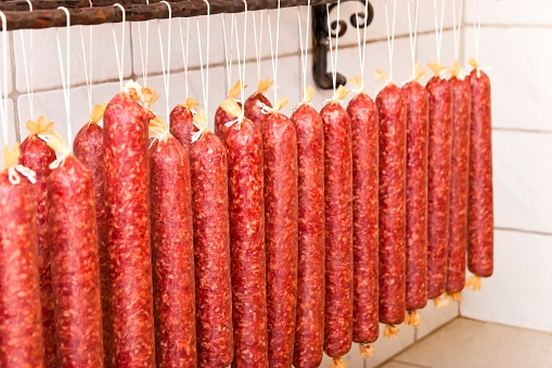 Freshly prepared salami in a butcher's display. The salami sausage is also called Italian  sausage or pepperoni in America.
This image is part of a series.