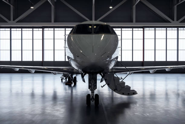 Luxury private jet plane in aviation hangar Luxury business jet airplane being stored inside an aviation hangar turbojet engine photos stock pictures, royalty-free photos & images