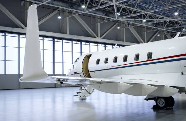 Luxury private jet plane in aviation hangar Luxury business jet airplane being stored inside an aviation hangar airplane hangar stock pictures, royalty-free photos & images