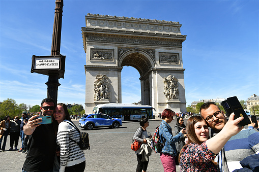 Paris, France-04 17 2022: Tourists taking selfies in front of the Arc de Triomphe, Paris, France.