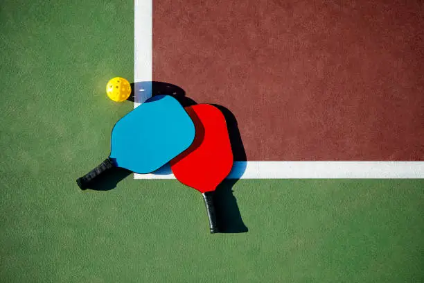 Photo of Pickleball Paddles and Balls on a court