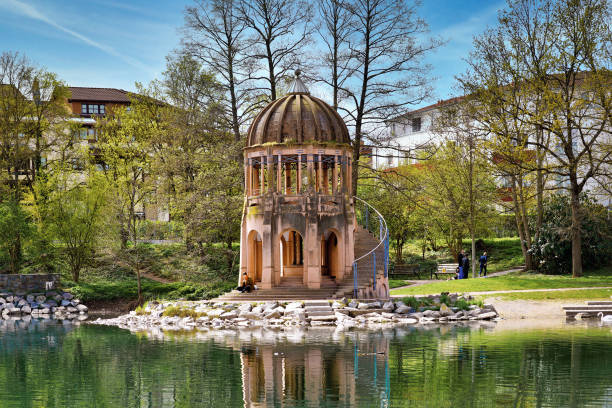 Freiburg, Germany - April 2022: Small tower called 'Tempelchen' at lake in park on sunny spring day