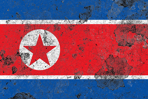North korea flag on a damaged old concrete wall surface
