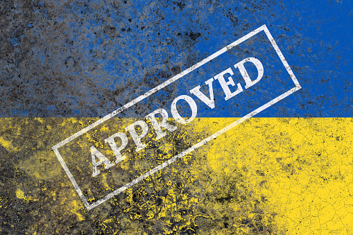 Rustic ukraine flag with approved label on a damaged old concrete wall surface