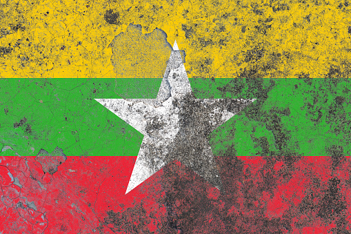 Myanmar flag on a damaged old concrete wall surface