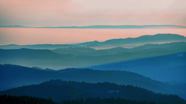 beau panorama paysager dans la forêt-noire - vue pendant le coucher de soleil dans les montagnes, les collines, les arbres forestiers dans la forêt noire, avec un brouillard brumeux et un ciel rougeoyant. - forest black forest sky night photos et images de collection