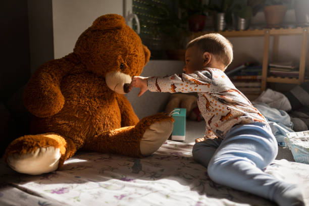 Toddler playing with a teddy bear