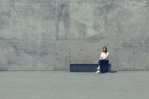 woman sitting on a bench in urban surrounding. concept.