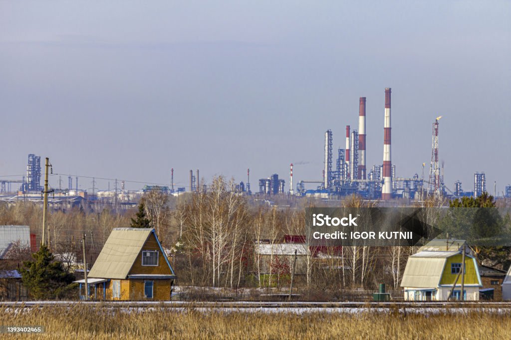 View from a suburban village to the oil refinery of a large industrial city. Approaching Stock Photo