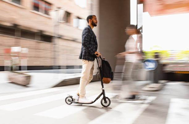 istock Businessman commuting in the city with a push scooter 1393409541