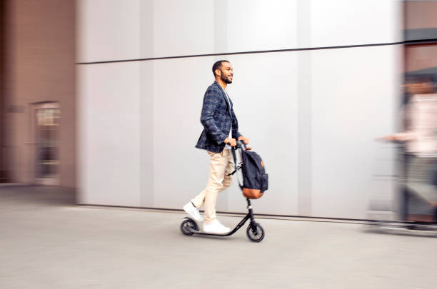 istock Businessman commuting in the city with a push scooter 1393409542