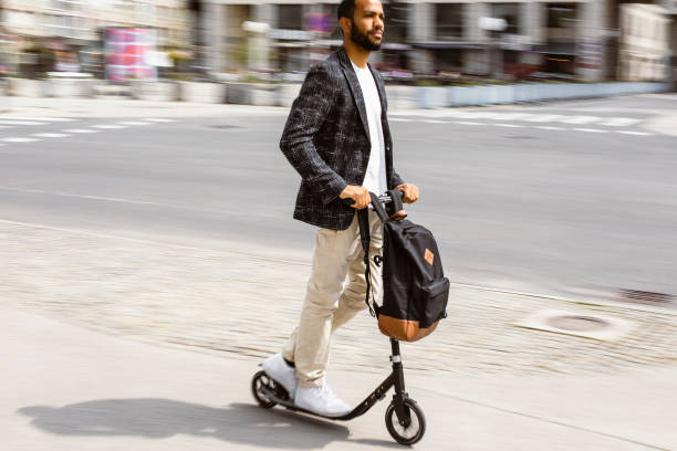 istock Businessman commuting in the city with a push scooter 1393409568