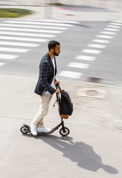 istock Businessman commuting in the city with a push scooter 1393409569