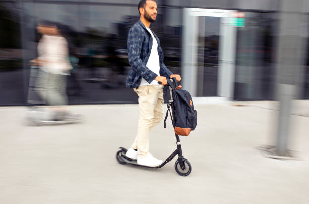 istock Businessman commuting in the city with a push scooter 1393409571