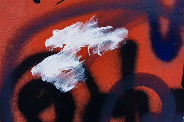 istock Traces of black and white paint on a red wall. 1393411704