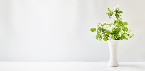 istock Spring flowers in a vase on a white table. Easter background with copy space 1393412041